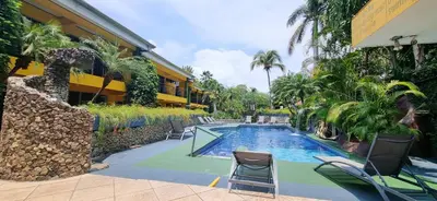 a swimming pool with chairs next to a building at Mangaby Playa Hermosa in Playa Hermosa