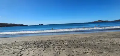 a group of people in the water at the beach at Mangaby Playa Hermosa in Playa Hermosa