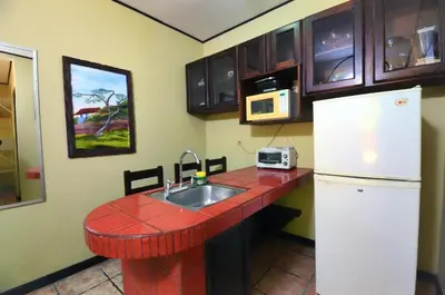 a kitchen with a counter with a sink and a refrigerator at Mangaby Playa Hermosa in Playa Hermosa