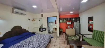 a bedroom with a large bed and a kitchen at Mangaby Playa Hermosa in Playa Hermosa