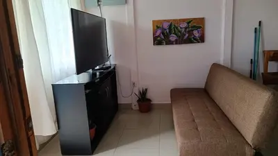 a living room with a couch and a flat screen tv at Casa de Campo Heliconia in Fortuna