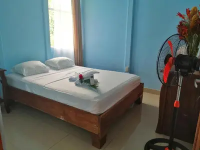 a bed in a blue room with a fan at Casa de Campo Heliconia in Fortuna