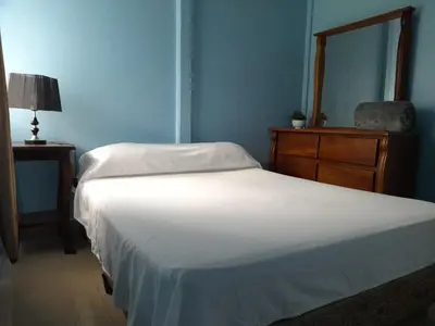 a bedroom with two beds and a dresser and a white bed at Casa de Campo Heliconia in Fortuna