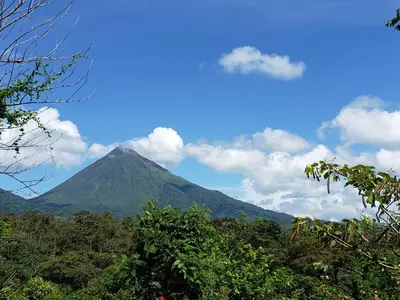 a mountain in the distance with trees in the foreground at Casa de Campo Heliconia in Fortuna