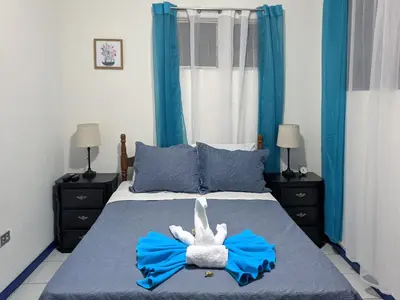 a bedroom with a bed with a stuffed animal on it at Entire Comfy apartment for you, 5 min SJO Airport in Alajuela City