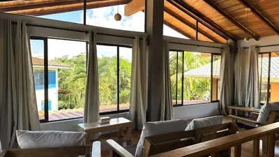 a living room with large windows and white chairs at Montezuma Hills - Twin Houses in private compound - 4' to Downtown in Montezuma