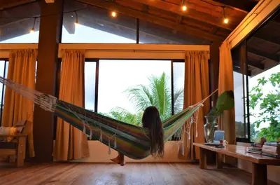 a woman laying in a hammock in a room at Montezuma Hills - Twin Houses in private compound - 4' to Downtown in Montezuma