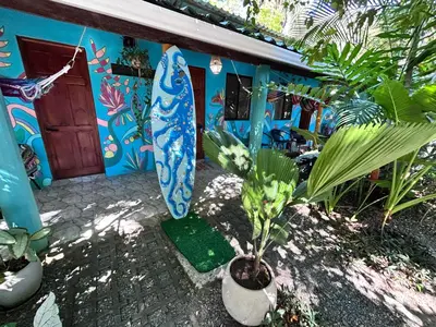a house with two surfboards in front of it at Boutique Rooms River Front at La Junta in Dominical
