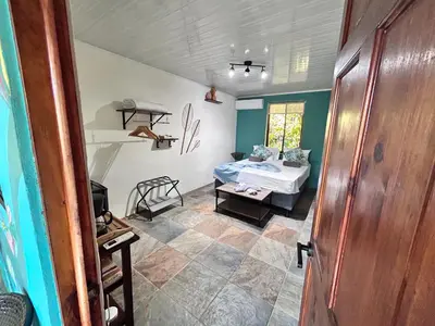 a room with a bed and a table in a room at Boutique Rooms River Front at La Junta in Dominical