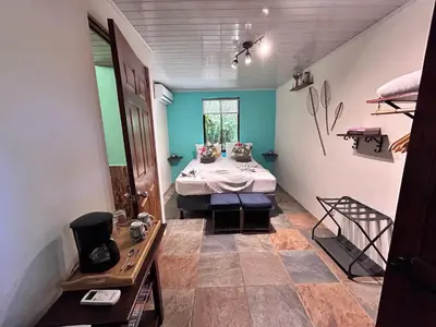 a room with a bed in the middle of a room at Boutique Rooms River Front at La Junta in Dominical