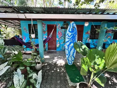 a house with surfboards painted on the side of it at Boutique Rooms River Front at La Junta in Dominical