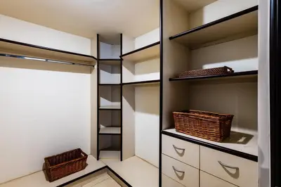 a walk in closet with white cabinets and baskets at LUXURY 3BR appt, CENTER, 2 min to BEACH, hi-speed wifi in Tamarindo
