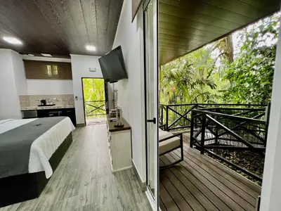 a bedroom with a bed and a balcony at Hotel Boutique Casa Del Rio in Fortuna