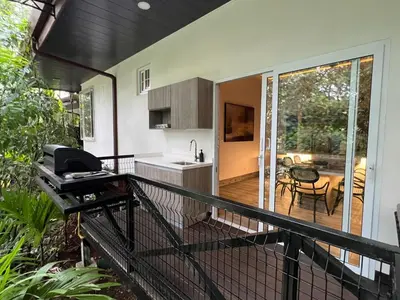 a balcony of a house with a grill and a kitchen at Hotel Boutique Casa Del Rio in Fortuna