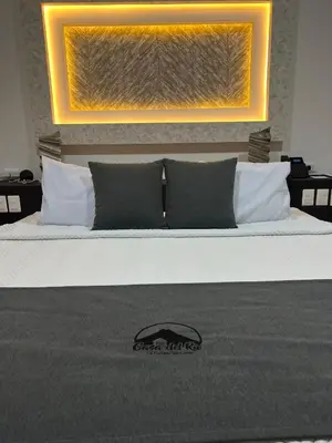 a bedroom with a bed with a picture on the wall at Hotel Boutique Casa Del Rio in Fortuna
