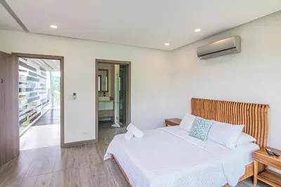 a bedroom with a white bed and a balcony at Luxury Villa #9 De Los Pájaros in Playa Hermosa