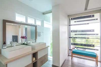a bathroom with two sinks and a mirror at Luxury Villa #9 De Los Pájaros in Playa Hermosa