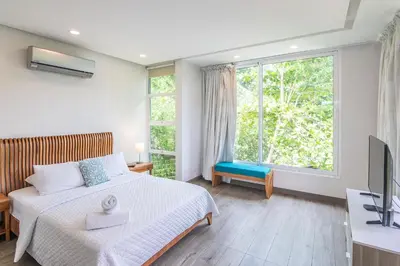 a bedroom with a bed and a large window at Luxury Villa #9 De Los Pájaros in Playa Hermosa
