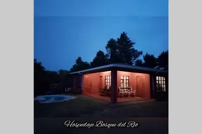 a house with a porch with a table and chairs at Hospedaje Bosque del Río in Monteverde Costa Rica
