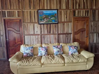 a living room with a couch with pillows on it at Hospedaje Bosque del Río in Monteverde Costa Rica