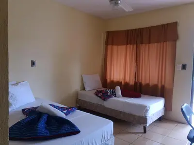 two beds in a room with a window at Hotel Real Alaska in Liberia