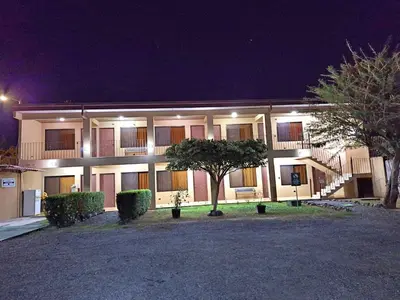 a building with a tree in front of it at night at Hotel Real Alaska in Liberia
