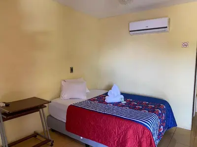 a bedroom with a bed with a blue box on it at Hotel Real Alaska in Liberia