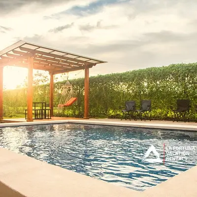 a swimming pool with a gazebo and a swing at Volcano view house la Fortuna in Fortuna