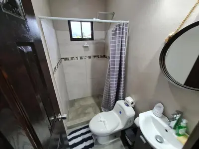 a bathroom with a sink and a toilet and a mirror at Volcano view house la Fortuna in Fortuna