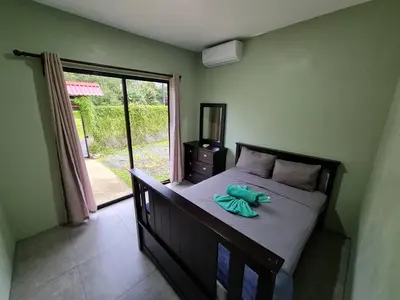 a bedroom with a bed and a window with a door at Volcano view house la Fortuna in Fortuna