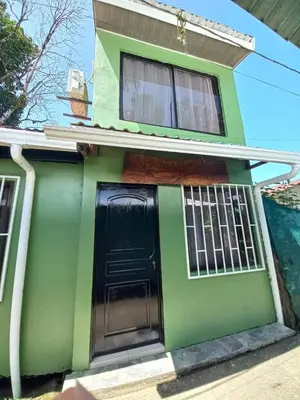 a green house with a black door at Apartamentos Caimán Tortuguero in Tortuguero