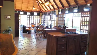 a kitchen with a island in a room with windows at Tropical Balinese Villa Atenas in Escobal