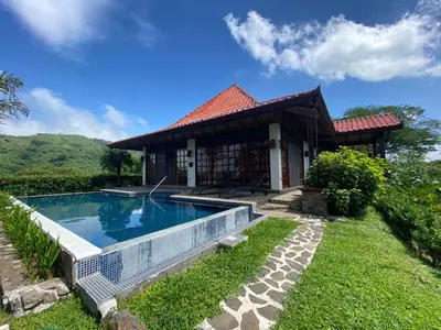 a house with a swimming pool in the yard at Tropical Balinese Villa Atenas in Escobal