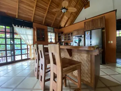 a kitchen with a bar with a table and chairs at Tropical Balinese Villa Atenas in Escobal