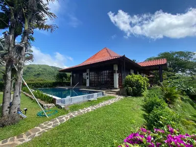 a house with a swimming pool in a yard at Tropical Balinese Villa Atenas in Escobal
