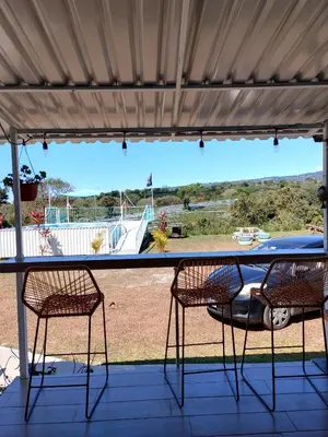 a table and two chairs on a porch with a view at Dreamcatcher House Bus Experience 2 in Sarchí