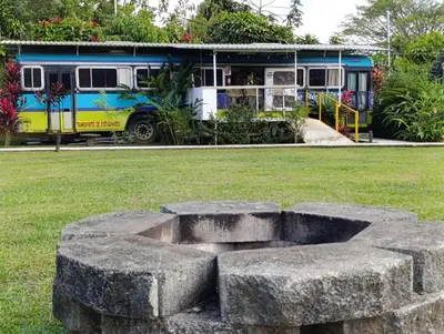 a bus is parked in a park with a stone circle at Dreamcatcher House Bus Experience 2 in Sarchí