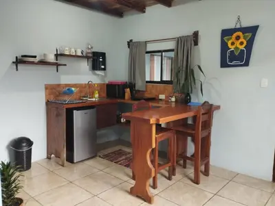 a kitchen with a wooden desk and a table at Apartamento Siary 1 in Monteverde Costa Rica
