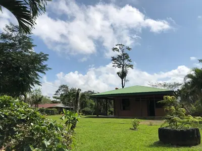a house with a green roof in a yard at Casita el jardin in Bijagua