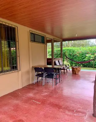 a patio with a table and chairs in a building at Casita el jardin in Bijagua