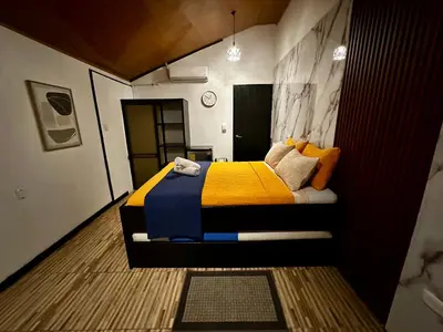 a bedroom with a bed with a yellow and blue blanket at Caribbean View in Tortuguero