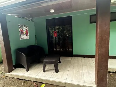 a room with two chairs and a table and a door at Caribbean View in Tortuguero