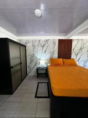 a bedroom with a bed with an orange bedspread at Caribbean View in Tortuguero
