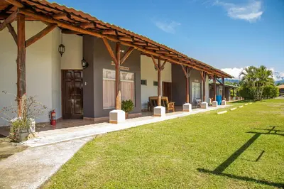 a row of houses with a grass yard at Hotel El Rancho in Quepos