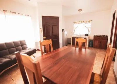 a living room with a wooden table and a couch at Hotel El Rancho in Quepos