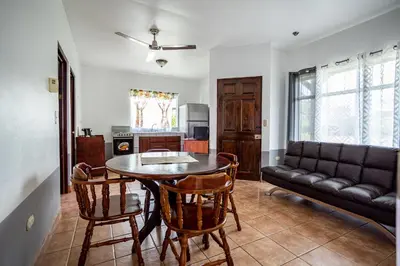 a living room with a table and chairs and a couch at Hotel El Rancho in Quepos