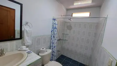 a bathroom with a shower and a toilet and a sink at Hotel Casa THIREMA Tortuguero in Tortuguero