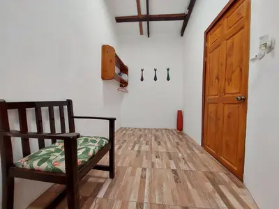 a room with a chair and a wooden door at Hotel Casa THIREMA Tortuguero in Tortuguero
