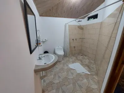 a bathroom with a sink and a toilet at Hotel Casa THIREMA Tortuguero in Tortuguero