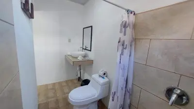 a bathroom with a white toilet and a sink at Hotel Casa THIREMA Tortuguero in Tortuguero